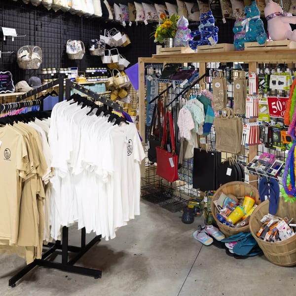 A retail display inside The Porch Breakfast & Brunch, featuring branded t-shirts, gifts, and accessories.
