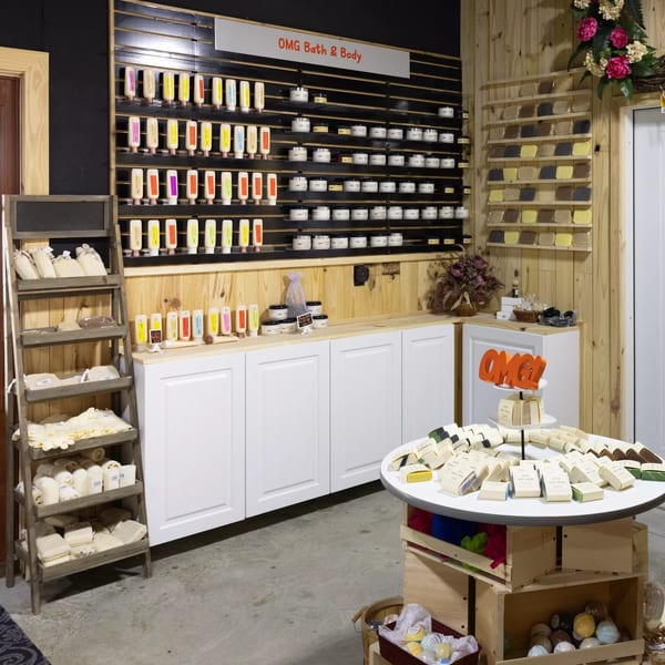 A retail display of bath and body products, including lotions, soaps, and bath bombs.