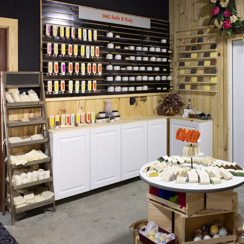 A retail display of bath and body products, including lotions, soaps, and bath bombs.